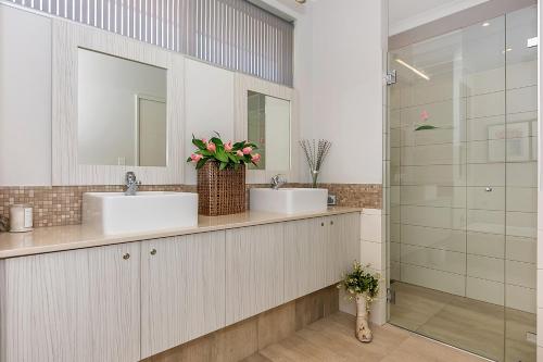 a bathroom with two sinks and a shower at Lavender Manor BnB in Alkimos