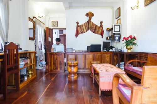 a man sitting at a desk in a room with a laptop at Villa Chitdara in Luang Prabang