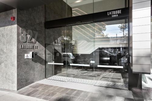 a glass door of a store with a reflection of a car at Platinum City Serviced Apartments in Melbourne