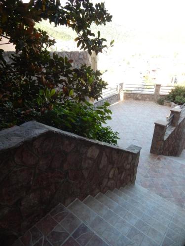 a patio with a stone wall and a bench at Contessa Apartments in Budva