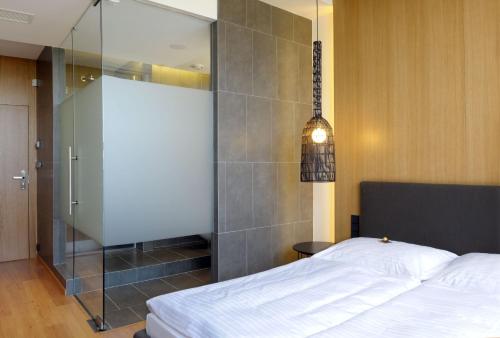 a bedroom with a bed and a glass shower at Hotel Tomášov in Zlín