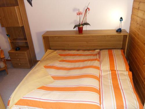 a bed with a striped blanket on it in a room at Hotel Alpina in Unterwasser
