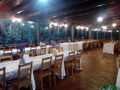 una grande stanza con tavoli e sedie con fiori di Agriturismo Agrimilo a Noto