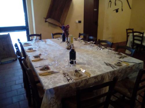 un lungo tavolo con bicchieri e una bottiglia di vino di Agriturismo Agrimilo a Noto