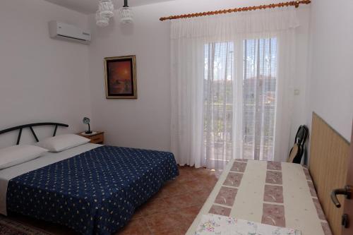 a bedroom with a bed and a large window at Guesthouse Meri in Fažana