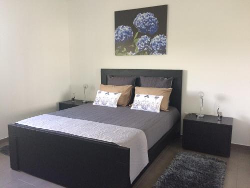 a bedroom with a large bed with two night stands at Vale dos Cocos in Horta