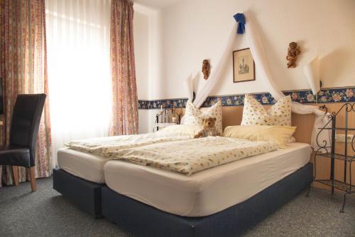 a bedroom with a large bed with a headboard at Hotel Goldenes Faß in Würzburg