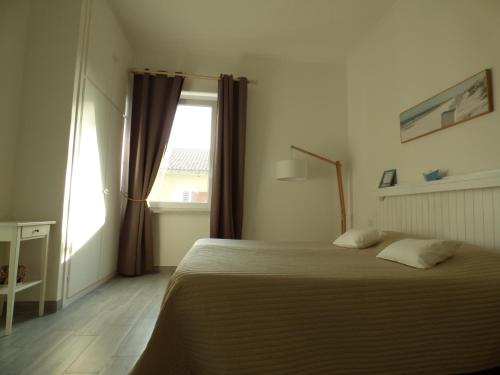 a bedroom with a bed and a window at One More Night in Fregene