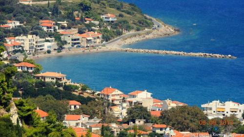 a group of houses on a hill next to the water at Hotel Pelagos Studios in Platána