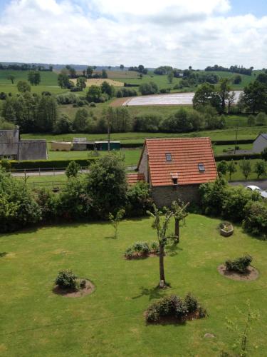 a house in a field with a tree in the grass at Normandy Nature Paradise in Vire