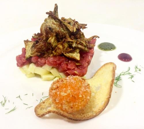 a plate of food with a piece of meat and vegetables at La Fucina di Vulcano in Bronte