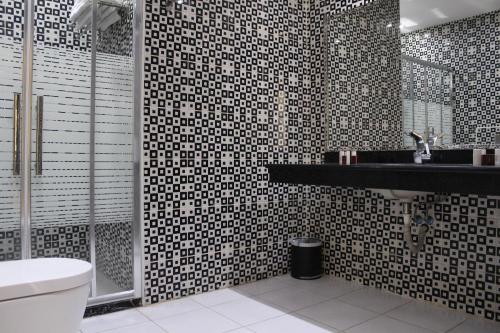 a bathroom with a black and white tiled wall at Rana Palace in Amman