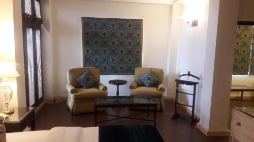 a living room with two chairs and a table at The Oaktree House in Shimla