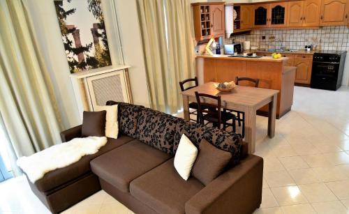 een woonkamer en een keuken met een bank en een tafel bij Daphne's Apartment in Athene