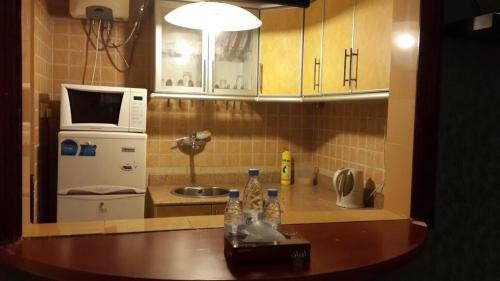 eine kleine Küche mit einer Spüle und einer Mikrowelle in der Unterkunft Almeswari Suites in Al Bahah