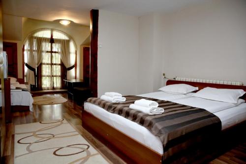 Un dormitorio con una cama grande con toallas. en St.St. Constantine and Helena, en Sandanski
