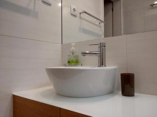 ポボア・デ・バルジンにあるHarbour Views Penthouseの白いバスルームの洗面台(カウンターの蛇口付)