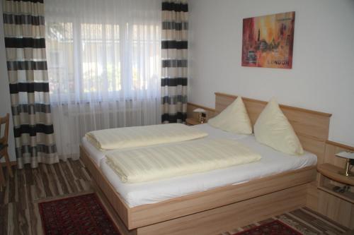 a bedroom with a bed with white sheets and a window at Ferienanlage Seehof in Krumpendorf am Wörthersee