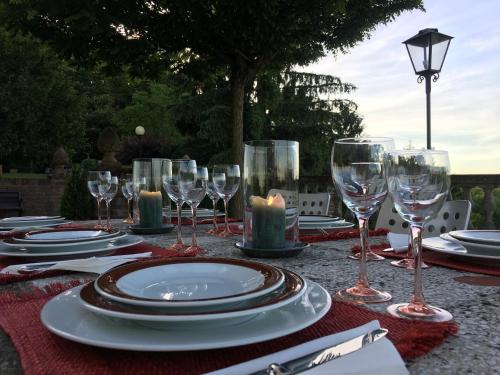 un tavolo con piatti e bicchieri da vino sopra di La Corte Delle 4 Stagioni a Ozzano Monferrato