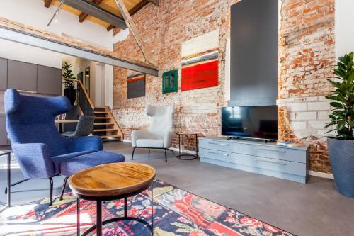 a living room with blue chairs and a television at alte Molkerei in Lindern