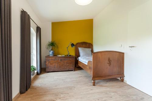 a bedroom with a bed and a yellow wall at alte Molkerei in Lindern