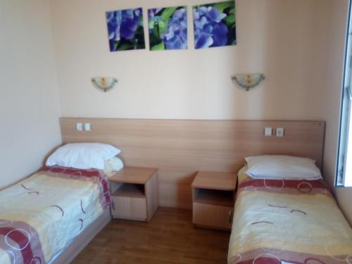 una camera con due letti e un tavolo e alcune immagini di Guest House Pri Germanetsa a Pavel Banya