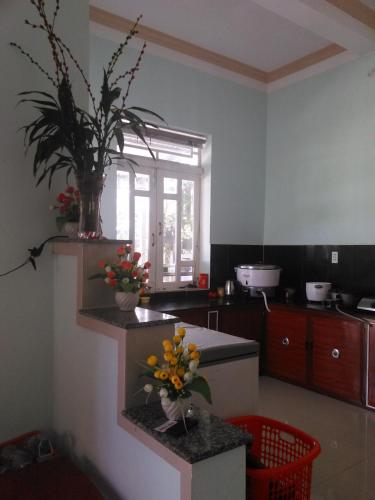 a kitchen with a vase of flowers on a counter at Tuan Thanh Homestay in Tân Hiệp