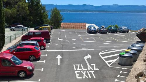 a parking lot with cars parked next to the water at Apartment Ariana in Bol