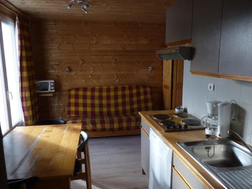 uma cozinha com um lavatório, uma mesa e um balcão em Les Amborzales em Le Grand-Bornand