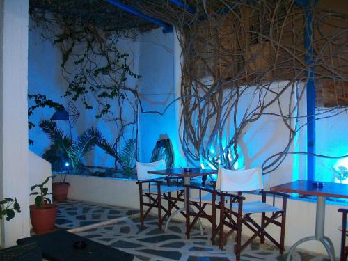 a table and chairs in a room with a blue wall at Princess Sissy in Ios Chora