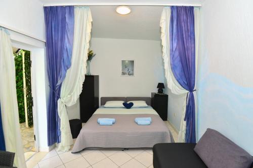 斯普利特的住宿－維可公寓酒店，一间卧室配有一张带紫色窗帘的床和一张沙发