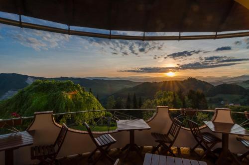 a balcony with tables and chairs and a sunset at Biolandhaus Arche in Eberstein