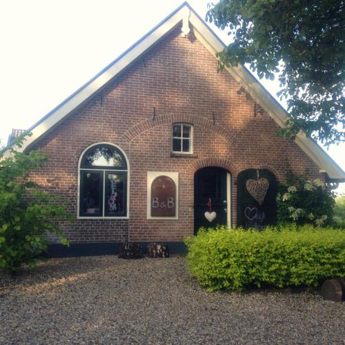 a red brick house with two windows and a door at Bed and Breakfast Klein Groenbergen in Leersum