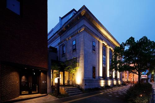a building with lights on the side of a street at HakoBA Hakodate by THE SHARE HOTELS in Hakodate