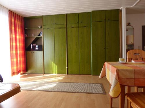 ホークジールにあるFerienwohnung Goldblume Hooksiel Nordseeの緑の部屋(テーブル、緑のキャビネット付)