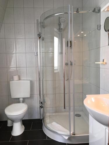 a bathroom with a shower and a toilet and a sink at Hotel 1912 in Angermünde
