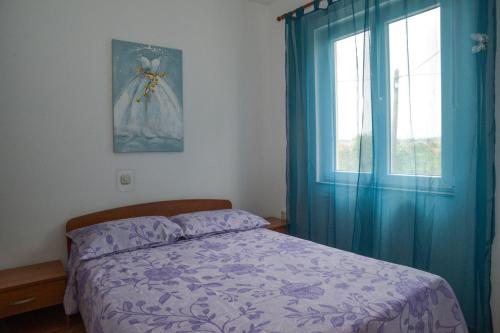 sypialnia z łóżkiem z niebieskimi zasłonami i oknem w obiekcie Latmo Apartment Zadar w mieście Zadar