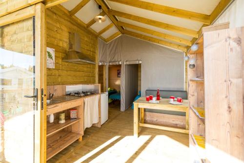 a large kitchen with wooden walls and a wooden floor at Camping Les Cent Chênes in Saint-Jeannet