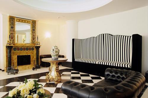 sala de estar con sofá, mesa y espejo en M Glamour Hotel, en Gabicce Mare