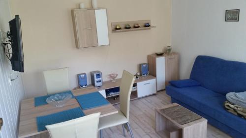 ein Wohnzimmer mit einem blauen Sofa und einem Tisch in der Unterkunft Ferienwohnung "Am Weinberg" in Bad Schmiedeberg
