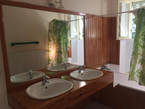 a bathroom with two sinks and a large mirror at Maison de famille Jo et Juliette in Suin