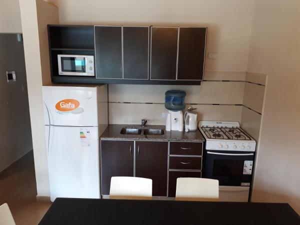 una pequeña cocina con armarios negros y refrigerador blanca en Altos de la Reserva en Costa del Este