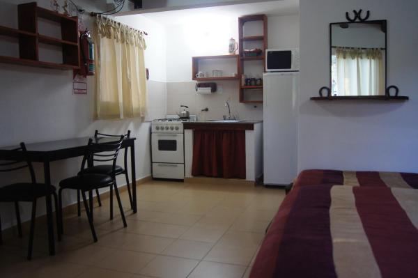Habitación con cocina, mesa y cama en La Herradura, en Mina Clavero