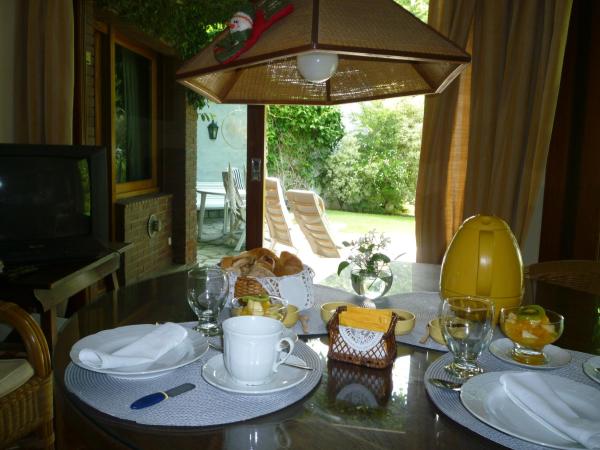 una mesa de comedor con platos y vasos. en Villa de la Costa en Chascomús