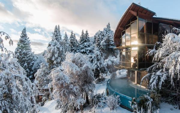 una casa en la nieve con una piscina en Design Suites Bariloche en San Carlos de Bariloche