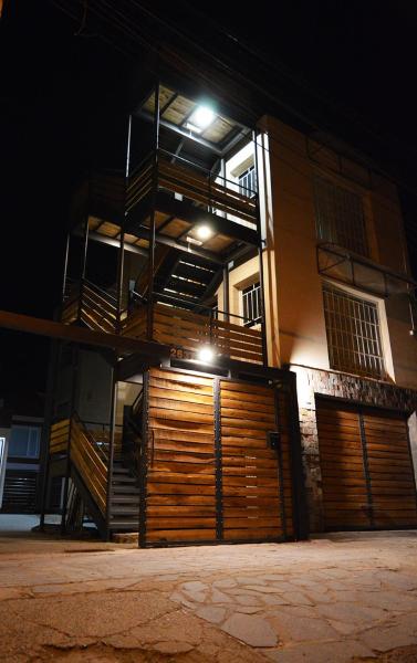 un edificio de apartamentos con puerta de madera en garaje por la noche en Wind Puerto Madryn en Puerto Madryn