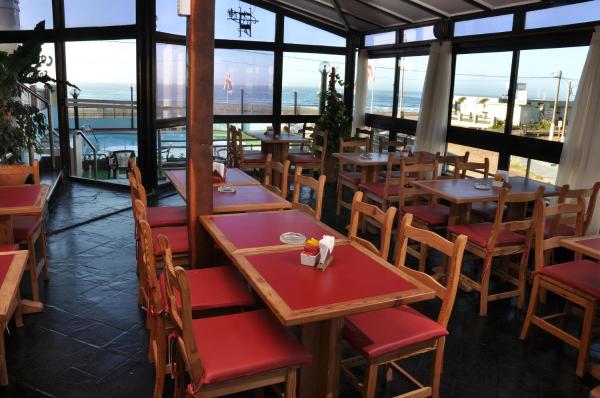 un restaurante con mesas y sillas con vistas al océano en Complex Marges en Villa Gesell