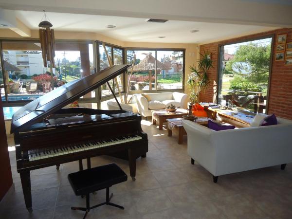 una sala de estar con un piano y un sofá en el Alpemar Apart Hotel & Spa en Villa Gesell