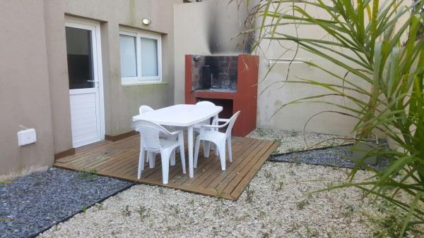 una mesa blanca y sillas en una terraza de madera en Punta 28 en Las Gaviotas