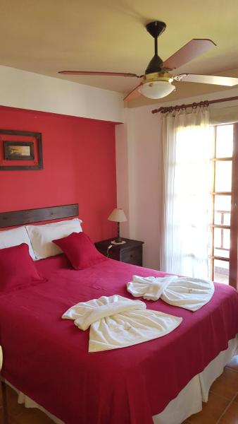 un dormitorio rojo con una cama grande con paredes rojas en el Aparte Familiar Antu Alen I en Villa Gesell